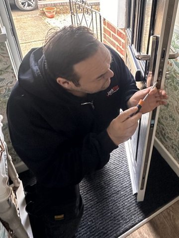 Mike (Mickey the Pick), local locksmith, working on a front door lock